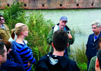 Mead Allison, center, professor of earth and environmental sciences, leads scientists on a New Orleans levee tour concentrated on the effects of subsidence, hurricanes and wetlands loss and ways to restore and protect the area. Photo was used with the Dec. 2, 2013, New Wave article, "Scientists pull together on global problem of coastal subsidence" and the March 2014, Tulane Magazine article, "Coastal flooding."